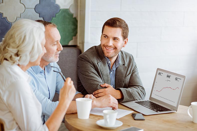 A 55+ couple talking over their homebuying questions with their Realtor.