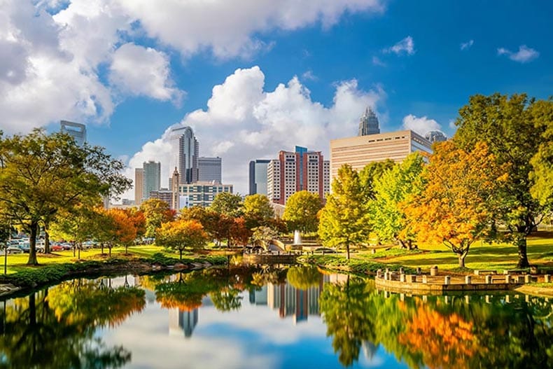 The skyline of Uptown Charlotte and the lake at Marshall Park.