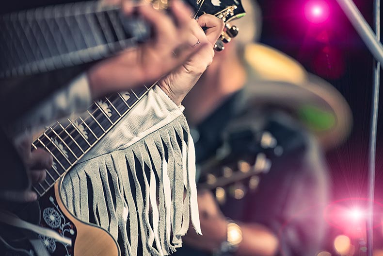 Closeup on a guitar player in a country band.