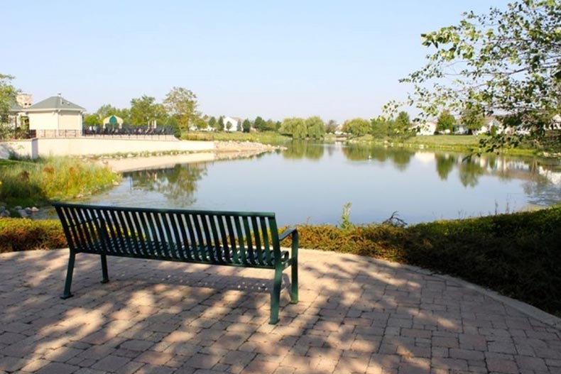 A bench beside a pond on the grounds of Grand Haven in Romeoville, Illinois.