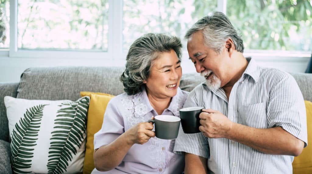 A senior couple smiling after applying for a reverse mortgage.