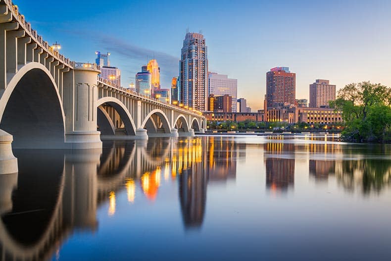 The downtown skyline on the Mississippi River with the Third Avenue Bridge at twilight in Minneapolis, Minnesota, USA.
