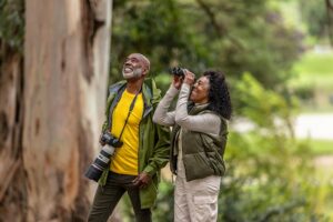 Two retirees enjoy bird watching, a favorite among hobbies for seniors.