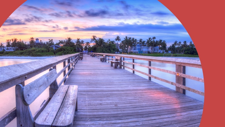 Sunrise over Naples Pier where people fish at dawn in Naples, Florida.