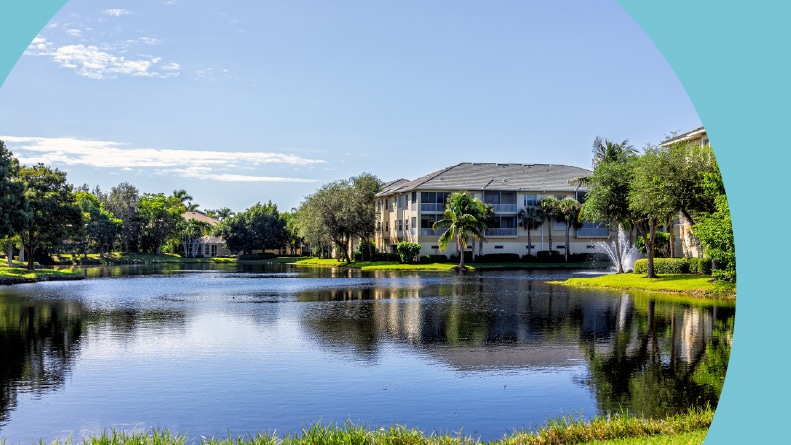 A community park with a lake and green grass in Pelican Bay in Naples, Florida on a sunny day.