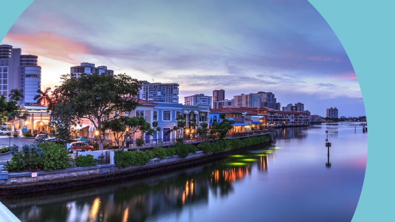 A pink sunset over the colorful shops of the Village on Venetian Bay in Naples, Florida.