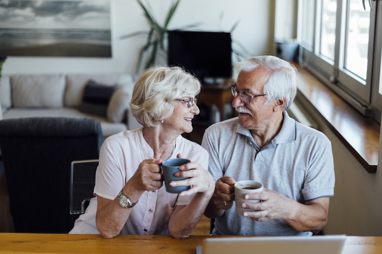 Retired couple enjoys coffee on the couch in their new Pulte Home.