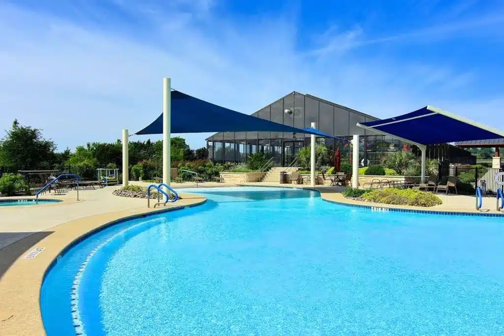 View of the outdoor pool, patio, and clubhouse at Sun City Texas. 