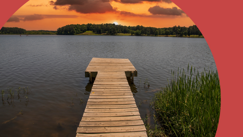 A wooden dock in Lake Acworth surrounded by green trees in Acworth, Georgia.