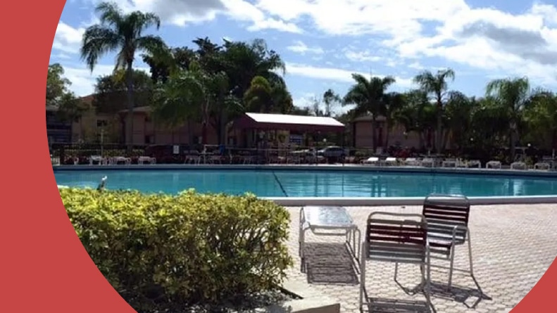 Lounge chairs beside the outdoor pool at Kings Point in Tamarac in Tamarac, Florida.