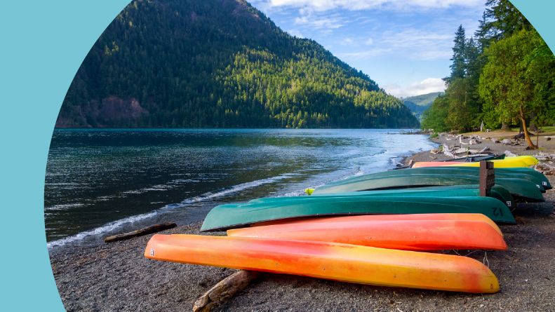 Row of colorful kayaks lying on the shore of Lake Crescent in Olympic National Park in Washington State.