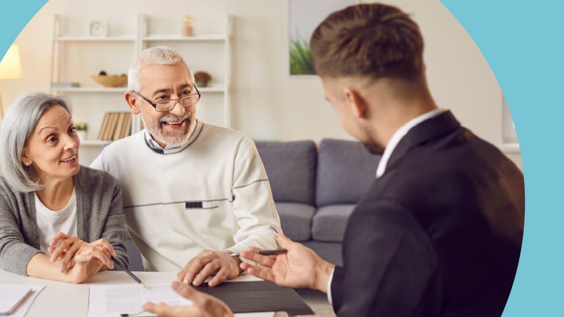A 55+ couple talking over their homebuying questions with their Realtor.