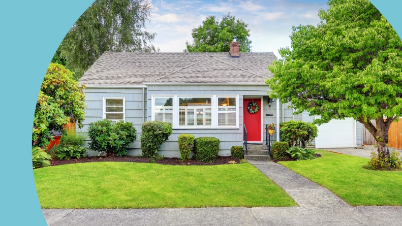 Exterior of small American house with blue paint and red door in a 55+ community.
