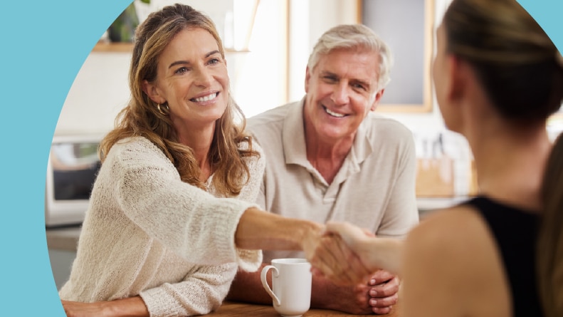 A 55+ homebuyer shaking hands with a Realtor after having her homebuying questions answered.