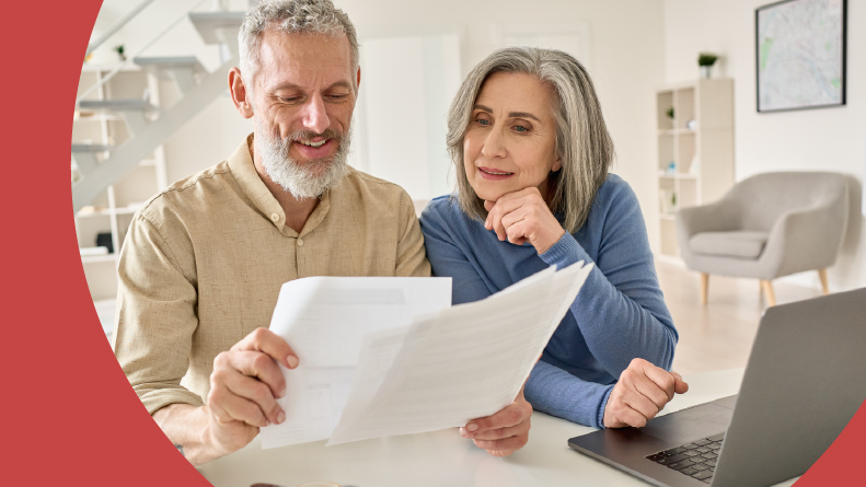 A 55+ couple looking over a rental agreement for a 55+ apartment community.
