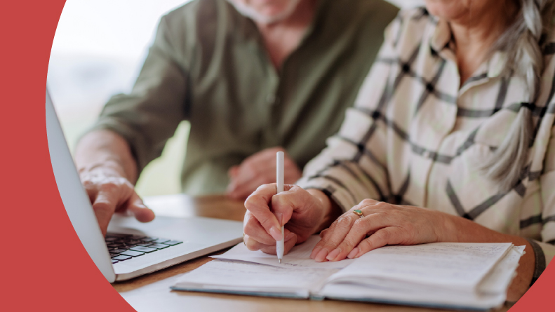 A senior couple calculate expenses together at home. See less