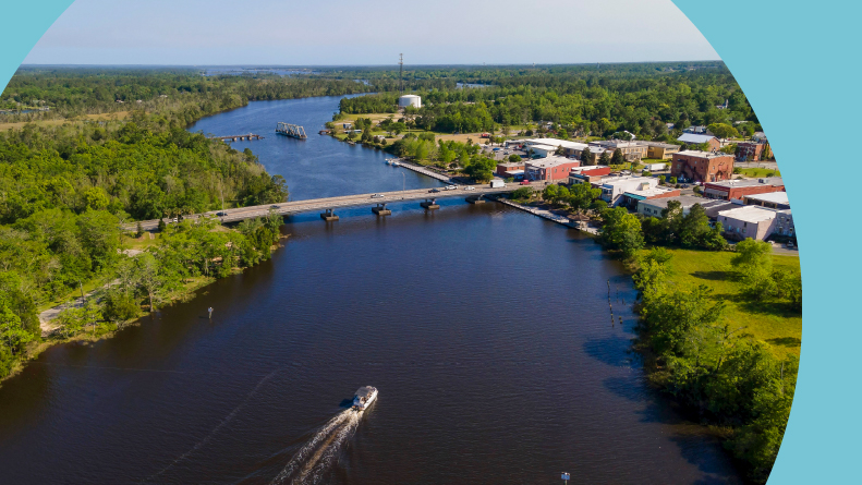 Wide river with passenger boat traveling under the bridges in Milton, Florida.