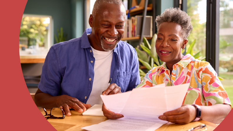 A smiling 55+ couple looking over their retirement finances.