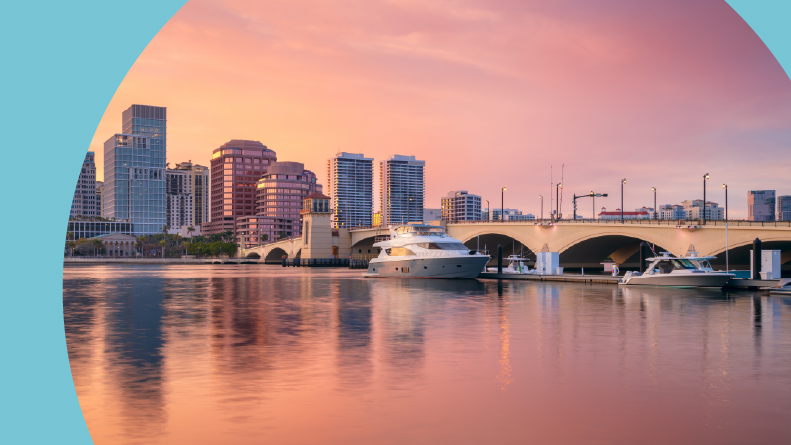 A reflection of the city skyline in the water at sunset in West Palm Beach, Florida.
