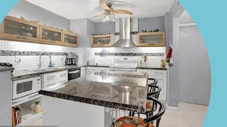 Interior view of a kitchen and a model home at Castle Gardens in Lauderhill, Florida.