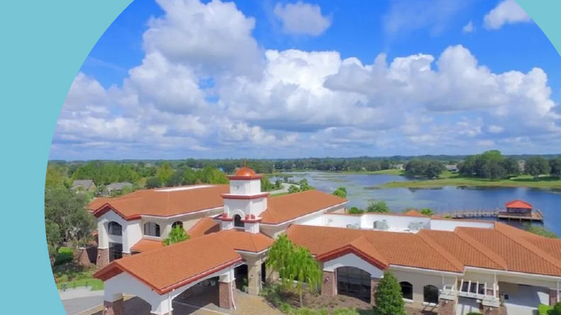 Aerial view of the clubhouse beside the lake at Del Webb Orlando in Davenport, Florida.