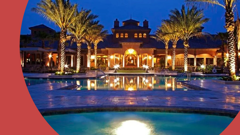 Palm trees surrounding the outdoor pool at night at Del Webb Ponte Vedra in Ponte Vedra, Florida.