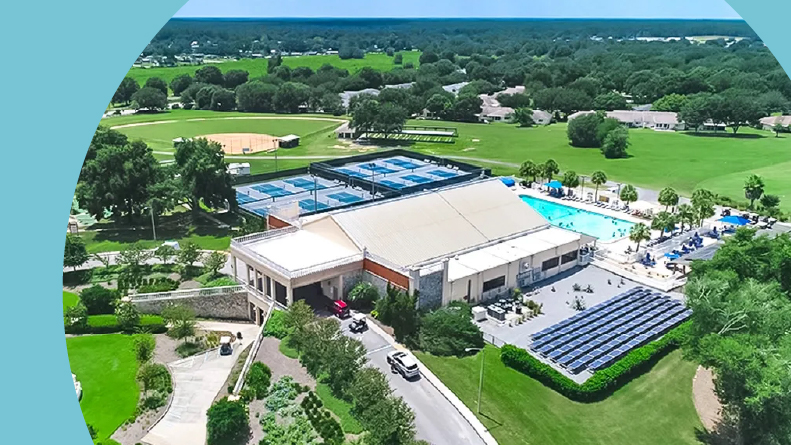 Aerial view of the clubhouse and outdoor amenities at On Top of the World, one of many stay and play retirement communities in Florida.