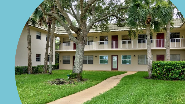 Exterior view of the condo building at Vista Gardens, one of many 55+ communities in Florida with low HOA fees.