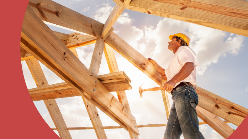 A builder working on a roof structure at a construction site.