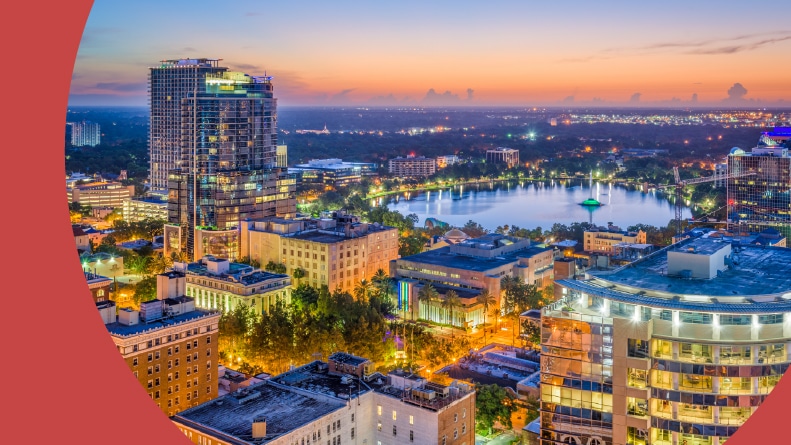 Aerial view of Lake Eola and the Orlando skyline at night.