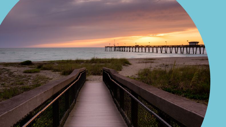 A sunset over a pier and boardwalk at Venice Beach, Florida.