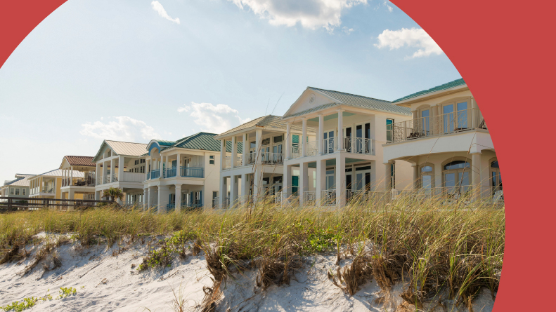 White sand dunes and three-story houses on the beach in Destin, Florida.