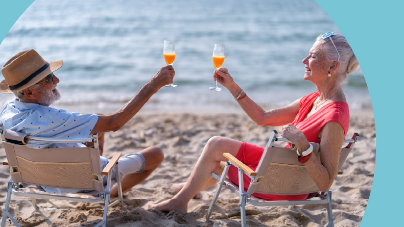 A 55+ couple on the beach enjoying drinks in Palm Beach County in Florida.