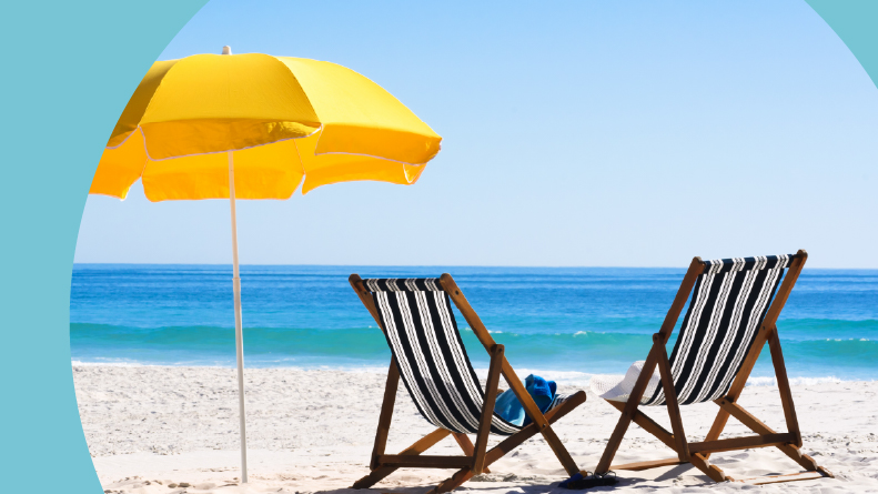 A pair of sun loungers and a beach umbrella on a beach.