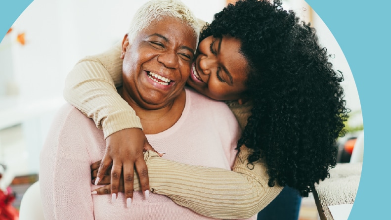 An adult daughter hugging her mother indoors at her home in a 55+ community.