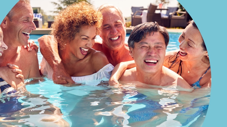 A group of 55+ friends enjoying an outdoor pool on a sunny day.