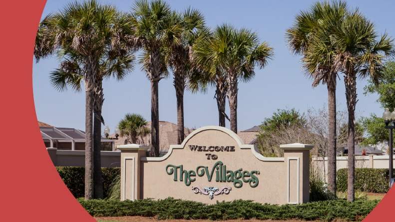 Palm trees surrounding the community sign for The Villages in Florida.