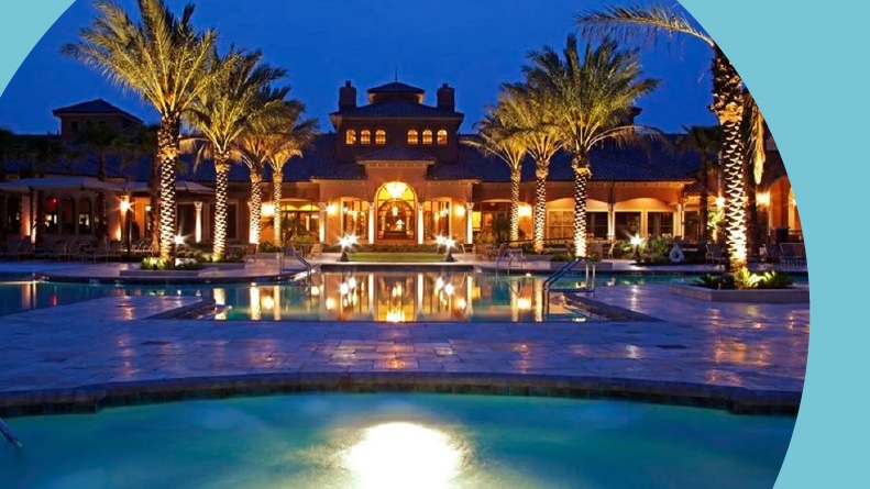 Palm trees surrounding the outdoor pool at Del Webb Ponte Vedra in Ponte Vedra, Florida at night.