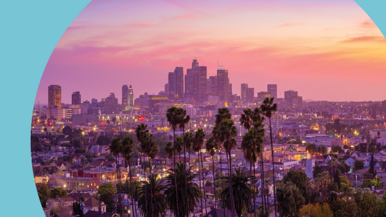 Sunset view with palm trees of Downtown Los Angeles, California.