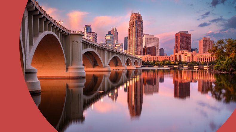 Downtown Minneapolis, Minnesota with a reflection of the city skyline in the Mississippi River at sunrise.