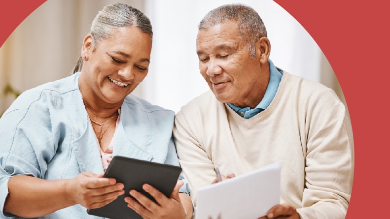 A 55+ couple with documents and a tablet for taxes.
