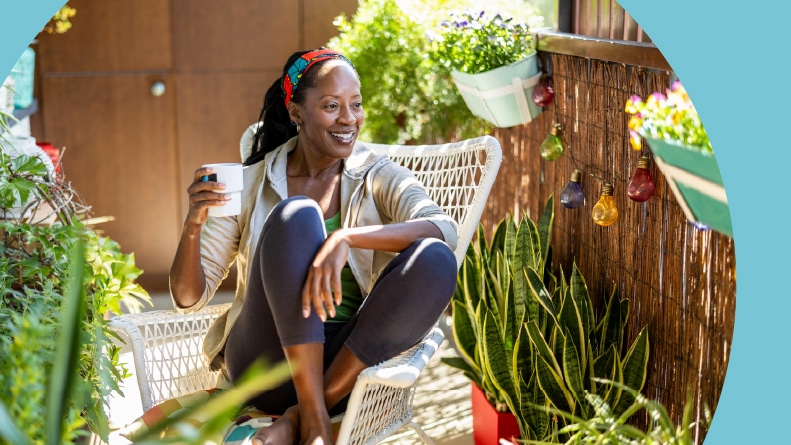 A 55+ woman relaxing on the balcony at home.