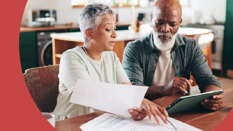 A 55+ couple looking over HOA paperwork at home.
