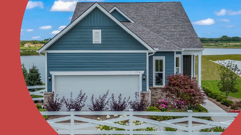 A white fence around a model home at Kensington Ridge by Del Webb in Milford, Michigan.