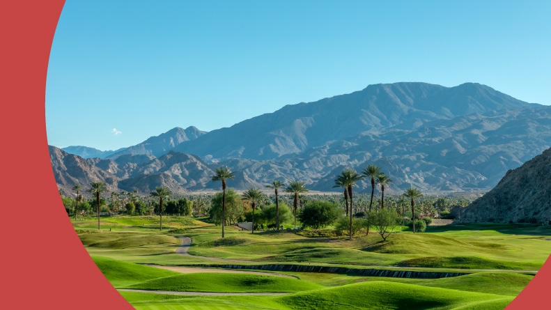 Green lawn and palm trees on a golf course in Palm Springs, California.