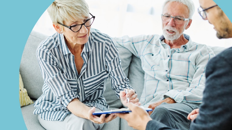 A 55+ couple signing a real estate contract.