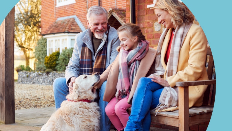 Grandparents with their granddaughter and dog getting ready to go for winter walk.