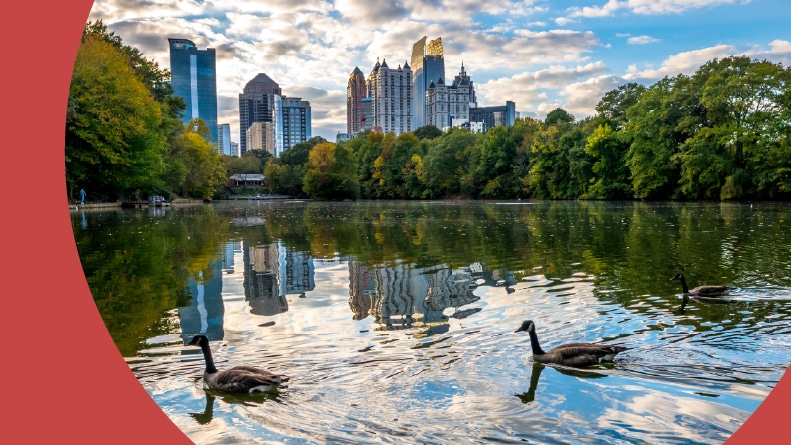 View of the skyline in Midtown Atlanta from the lake in Piedmont Park at sunset.