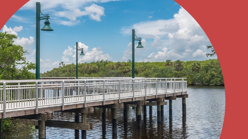 An elevated River Boardwalk in Port St. Lucie, Florida, at midday in summer.