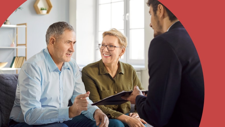 A 55+ couple discussing the capital gains tax with a financial advisor.